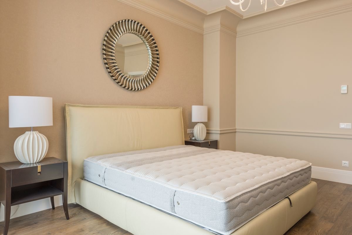 Wit matras op een boxspring in een lichte slaapkamer